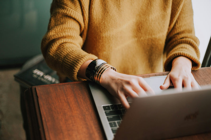 A person typing on a laptop at a desk